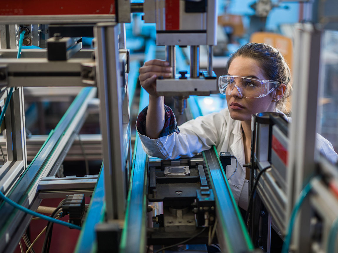Quality control worker analysing a machine part, Victoria, Australia